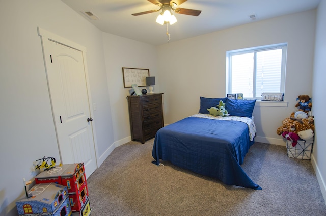 carpeted bedroom featuring ceiling fan, visible vents, and baseboards