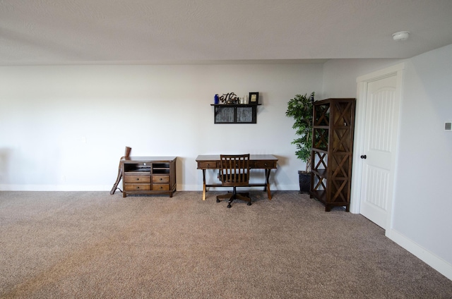 office area with a textured ceiling, carpet flooring, and baseboards