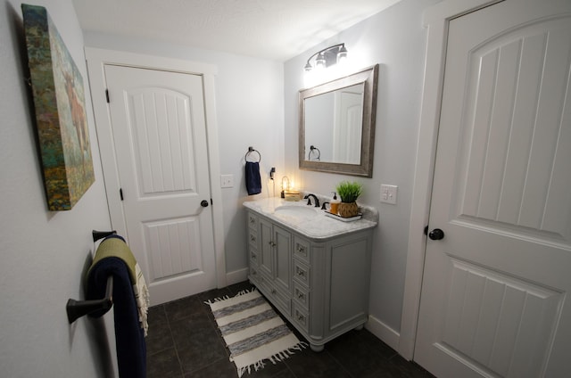 bathroom with tile patterned flooring, vanity, and baseboards