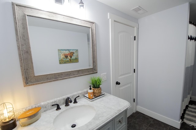 bathroom featuring baseboards, vanity, visible vents, and tile patterned floors