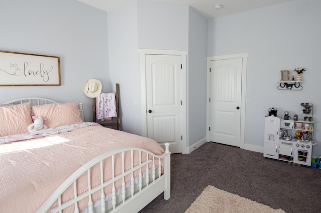 bedroom featuring baseboards and dark colored carpet