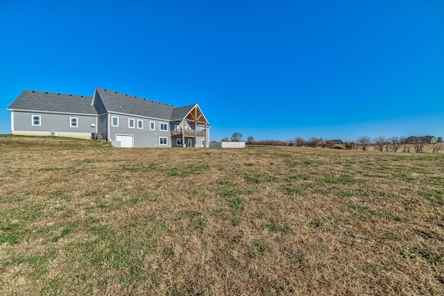 back of property with a lawn and a rural view