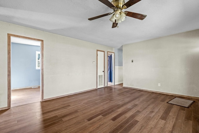 spare room featuring a textured ceiling, wood finished floors, and visible vents