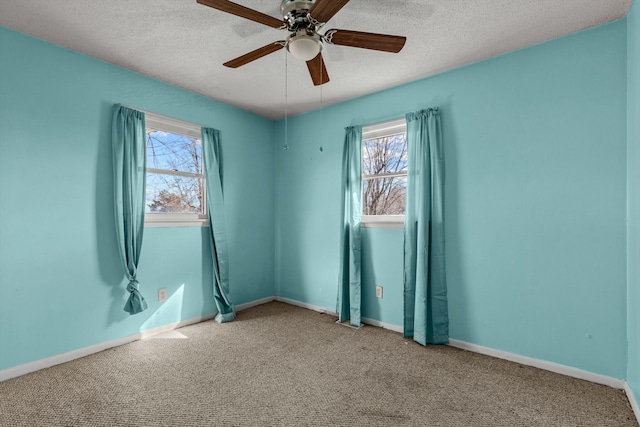 unfurnished room with light carpet, a textured ceiling, and baseboards