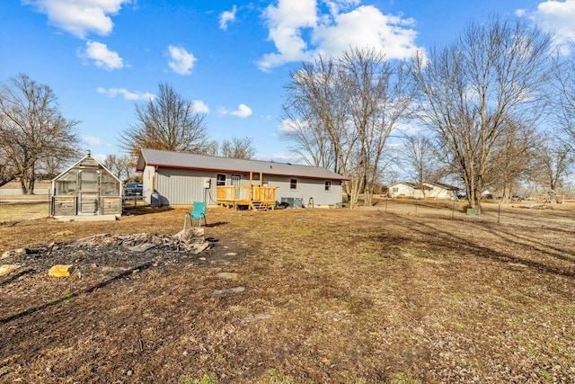 back of house with a deck, an outdoor structure, and an exterior structure