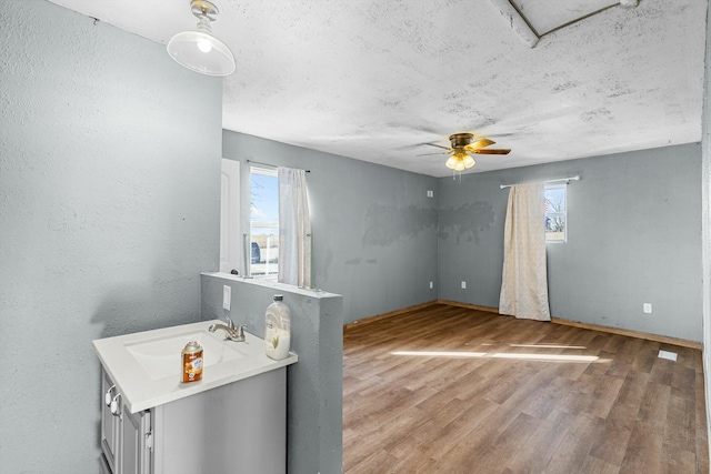 interior space with ceiling fan, light wood-type flooring, and a sink