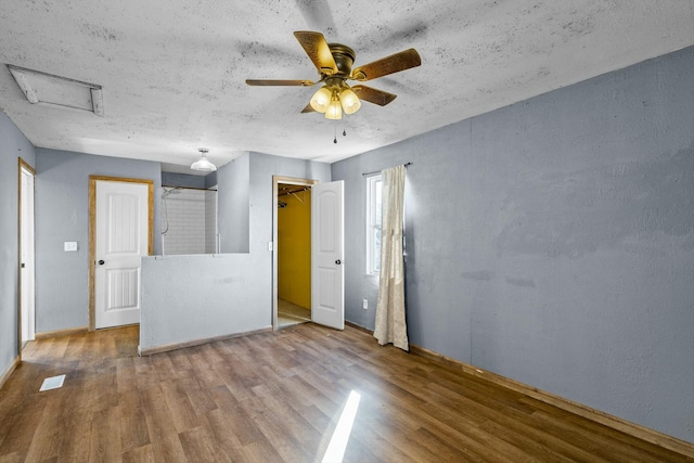 spare room featuring a textured ceiling, a ceiling fan, and wood finished floors