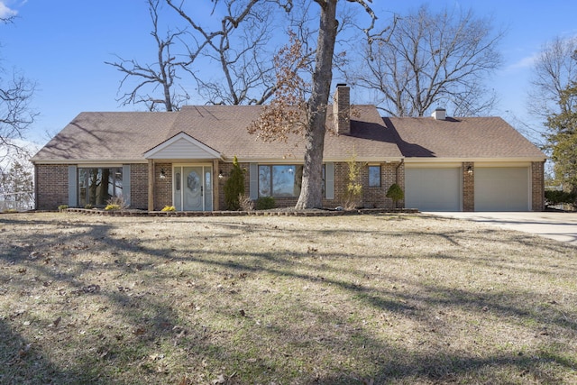 view of front of property featuring a garage, concrete driveway, brick siding, and a chimney