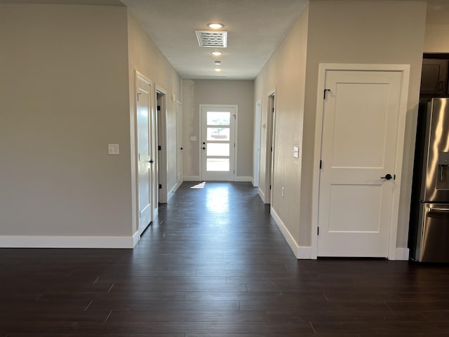 interior space featuring dark wood-style flooring, visible vents, and baseboards