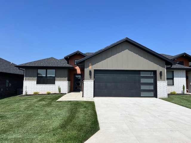 view of front facade featuring a garage, driveway, a front lawn, and brick siding