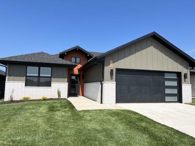 view of front of home featuring a front yard, brick siding, and an attached garage