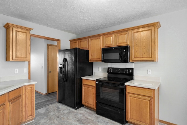 kitchen featuring black appliances, a textured ceiling, light countertops, and decorative backsplash