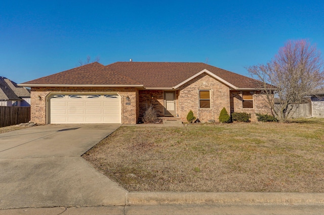 ranch-style house with brick siding, a shingled roof, concrete driveway, an attached garage, and a front yard