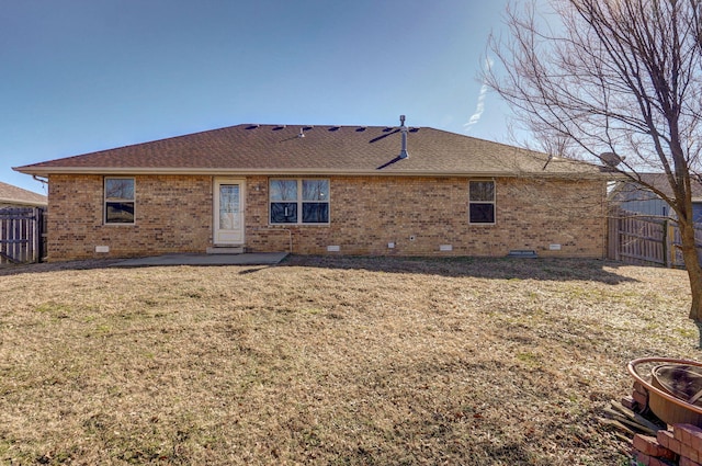 rear view of property featuring brick siding, crawl space, and fence