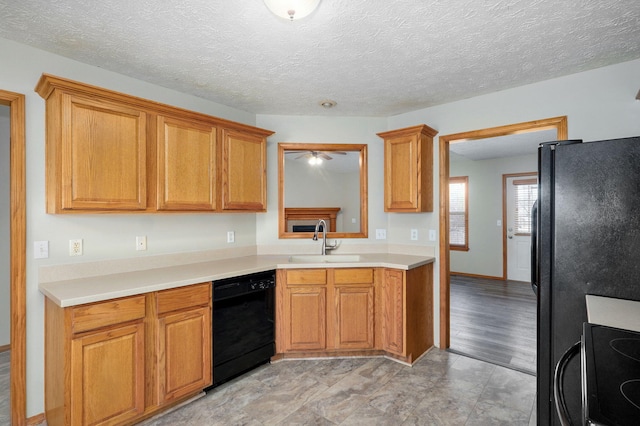 kitchen featuring brown cabinets, black appliances, light countertops, and a sink