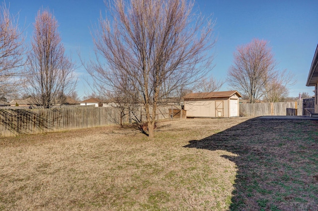 view of yard featuring a fenced backyard, a storage unit, and an outdoor structure