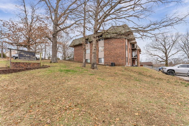 view of side of property with a lawn and brick siding