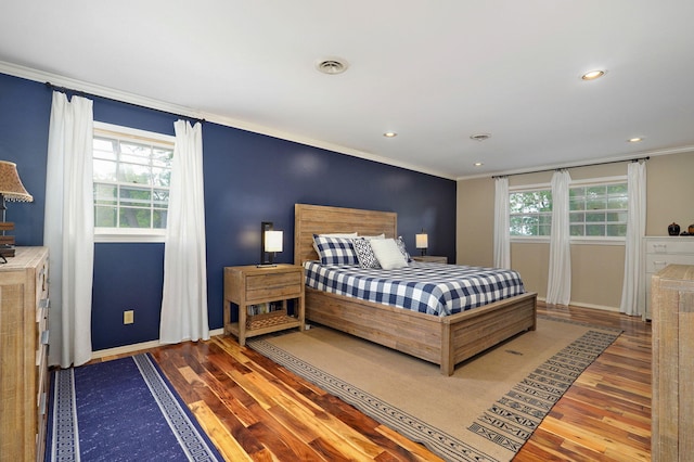 bedroom with visible vents, wood finished floors, and ornamental molding