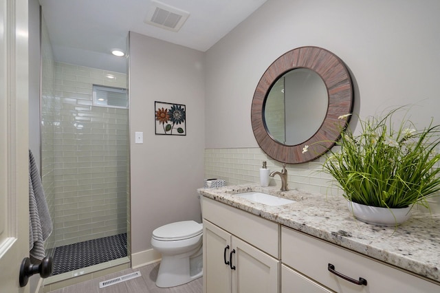 bathroom with toilet, visible vents, walk in shower, and vanity