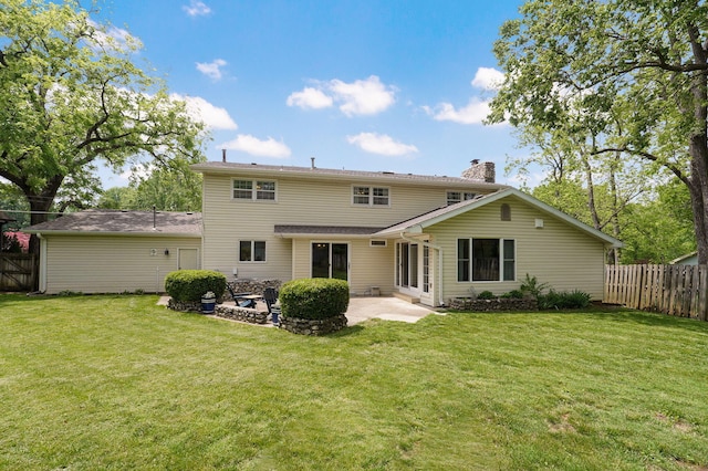 back of house featuring a yard, a patio, a chimney, and fence