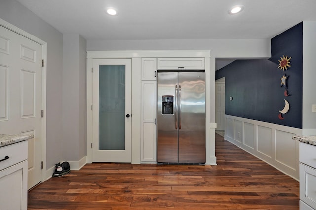 kitchen featuring white cabinetry, light stone counters, stainless steel refrigerator with ice dispenser, and dark wood-type flooring