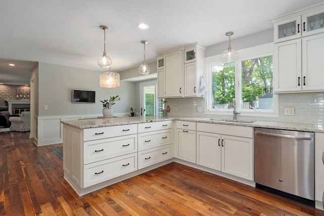 kitchen featuring hanging light fixtures, a peninsula, glass insert cabinets, and stainless steel dishwasher