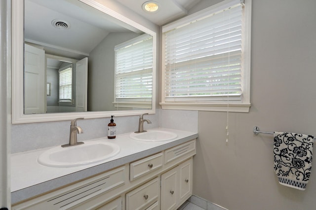 full bathroom with lofted ceiling, visible vents, a sink, and double vanity