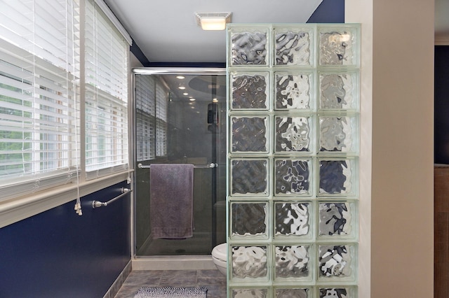 full bathroom featuring a shower stall, toilet, and tile patterned floors