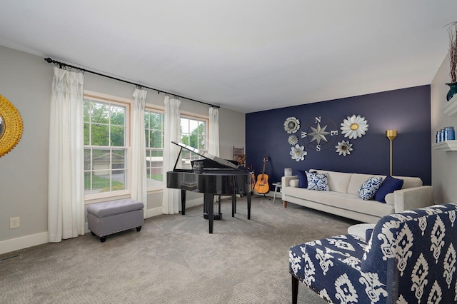 carpeted living room featuring an accent wall and baseboards