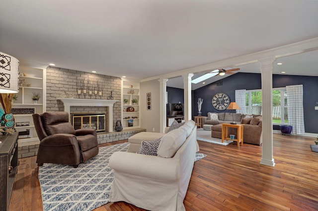 living area with ornate columns, a fireplace, built in features, and hardwood / wood-style floors