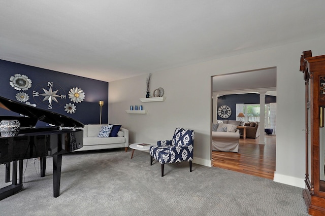 living area with carpet floors and ornate columns