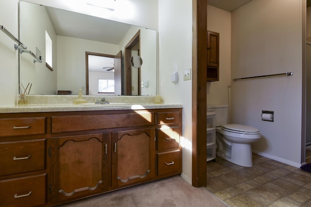 bathroom with toilet, baseboards, and vanity