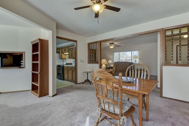 dining room with ceiling fan, baseboards, a textured ceiling, and light colored carpet