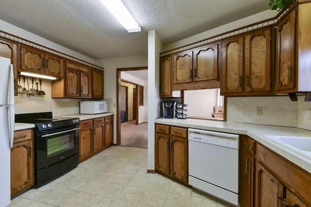 kitchen featuring brown cabinets, white appliances, light countertops, and light floors