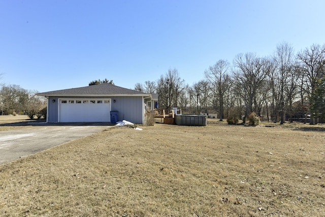 view of side of home featuring a garage, a pool, a lawn, and a wooden deck