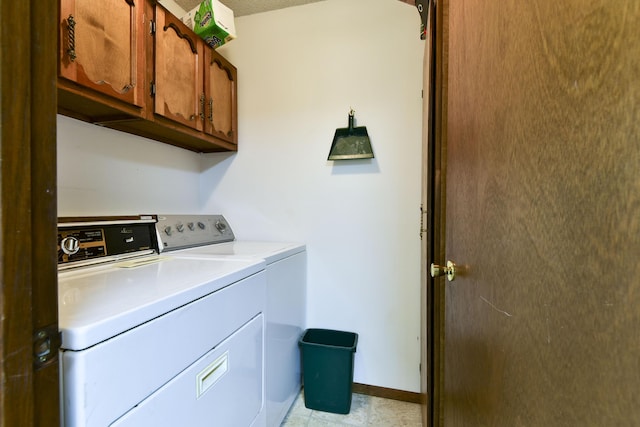 washroom with cabinet space, baseboards, and separate washer and dryer