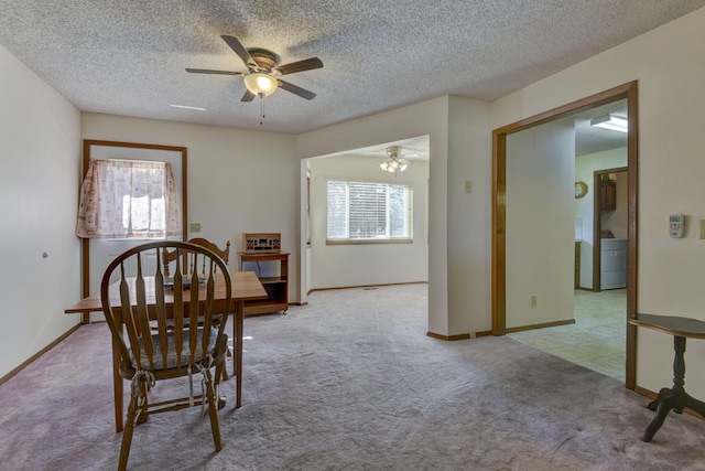 dining space featuring baseboards, ceiling fan, a textured ceiling, and light colored carpet