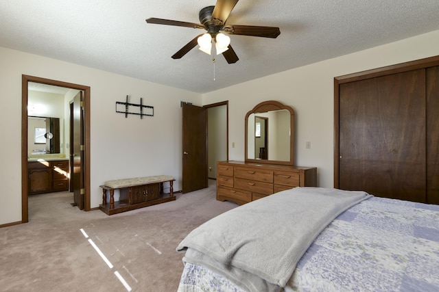 bedroom with light carpet, connected bathroom, a textured ceiling, and ceiling fan