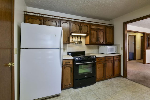 kitchen with dark brown cabinetry, white appliances, light colored carpet, light countertops, and a textured ceiling