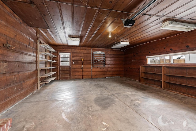 garage featuring wood walls, wood ceiling, and a garage door opener