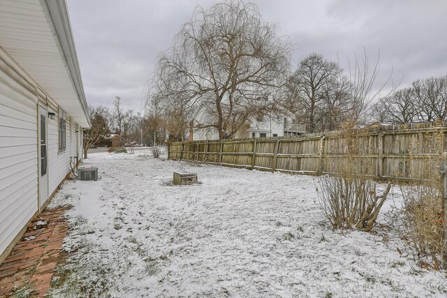 yard covered in snow with central AC unit and fence