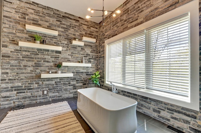 bathroom with tile patterned floors, an inviting chandelier, and a freestanding tub