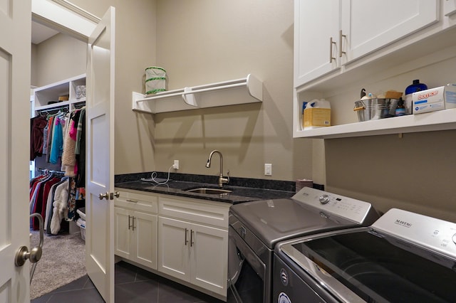 laundry room with dark tile patterned floors, washer and clothes dryer, a sink, dark carpet, and cabinet space