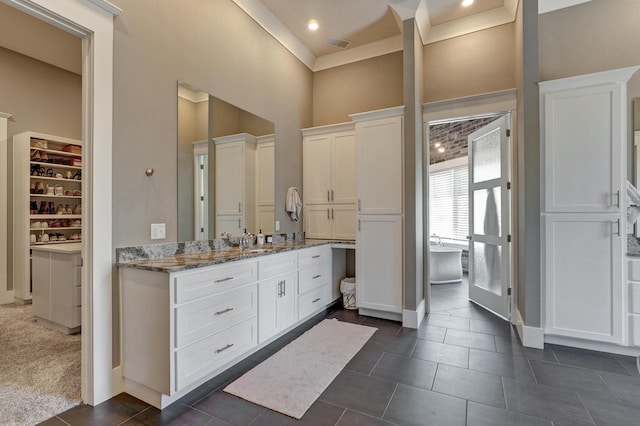 bathroom with crown molding, baseboards, a high ceiling, tile patterned floors, and vanity