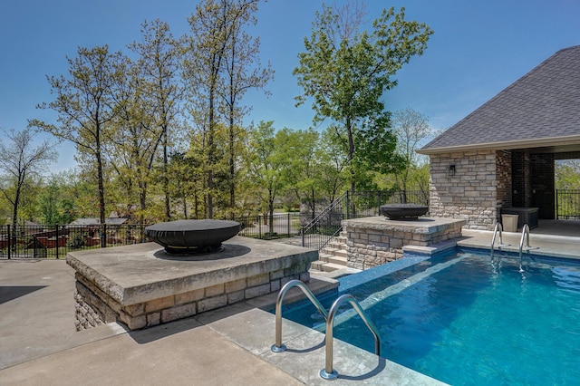 view of pool with a fenced in pool, a patio, fence, and an outdoor fire pit