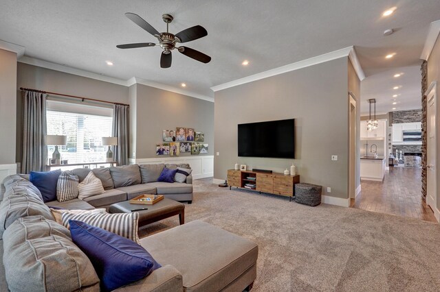 carpeted living room featuring a sink, recessed lighting, baseboards, and ornamental molding