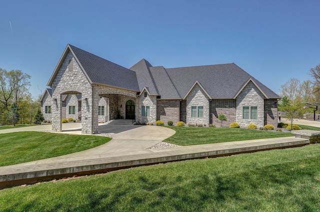 french country home featuring a front lawn and roof with shingles