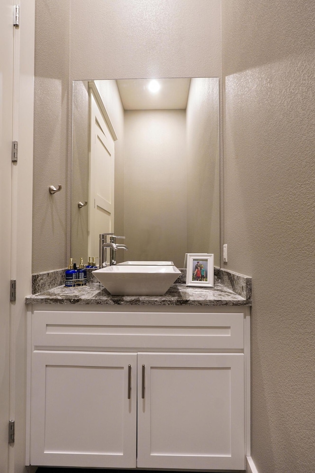 bathroom with vanity and a textured wall