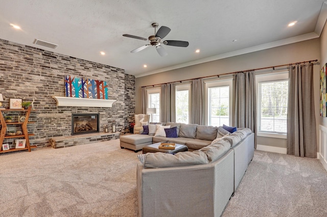 living area featuring a brick fireplace, visible vents, carpet floors, and a textured ceiling