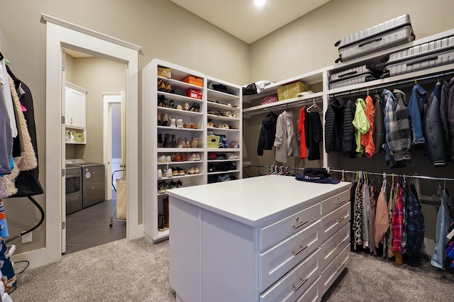 spacious closet with tile patterned flooring, carpet flooring, and separate washer and dryer